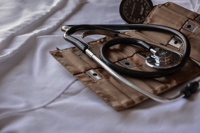 A stethoscope emphasizing mecfs on top of a bed.