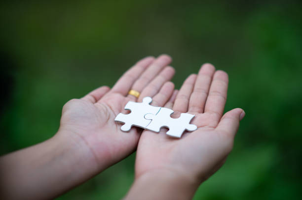 Two hands holding a piece of jigsaw puzzle depicting mecfs awareness.