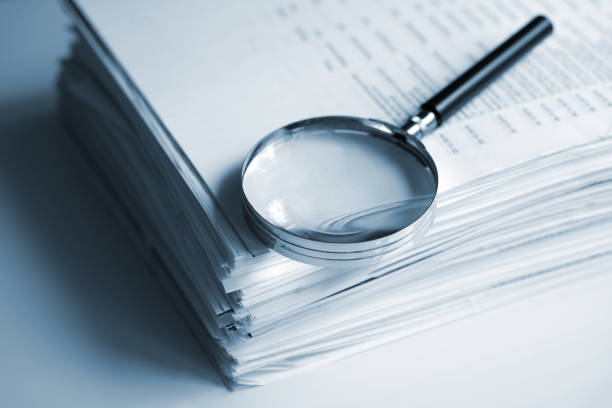 A magnifying glass inspecting documents.